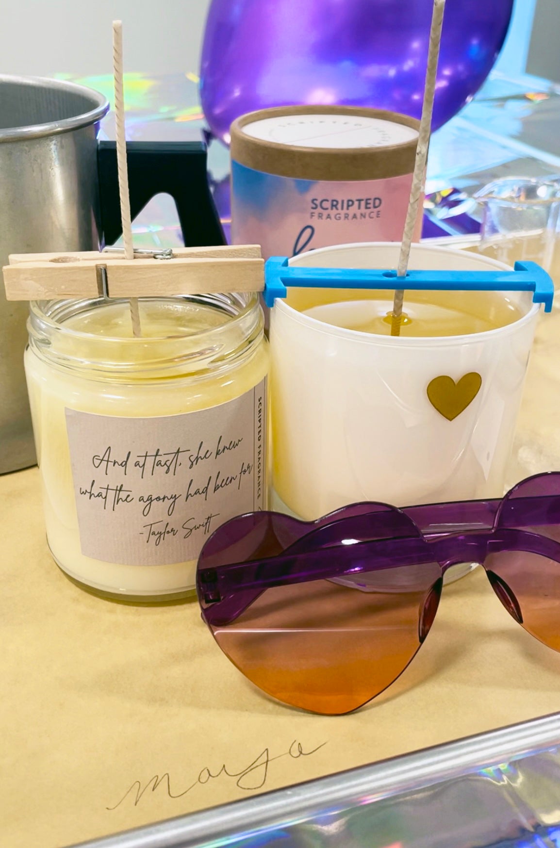 Finished soy candle next to sunglasses from a bachelorette class