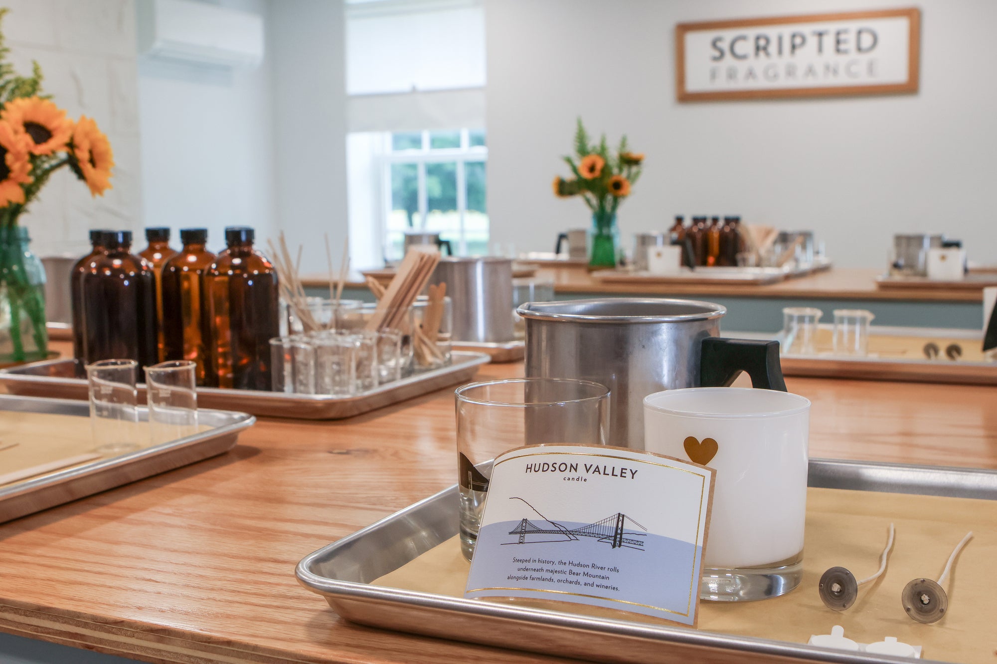 Fragrance oil bottles and supplies set up for a soy candle-making class