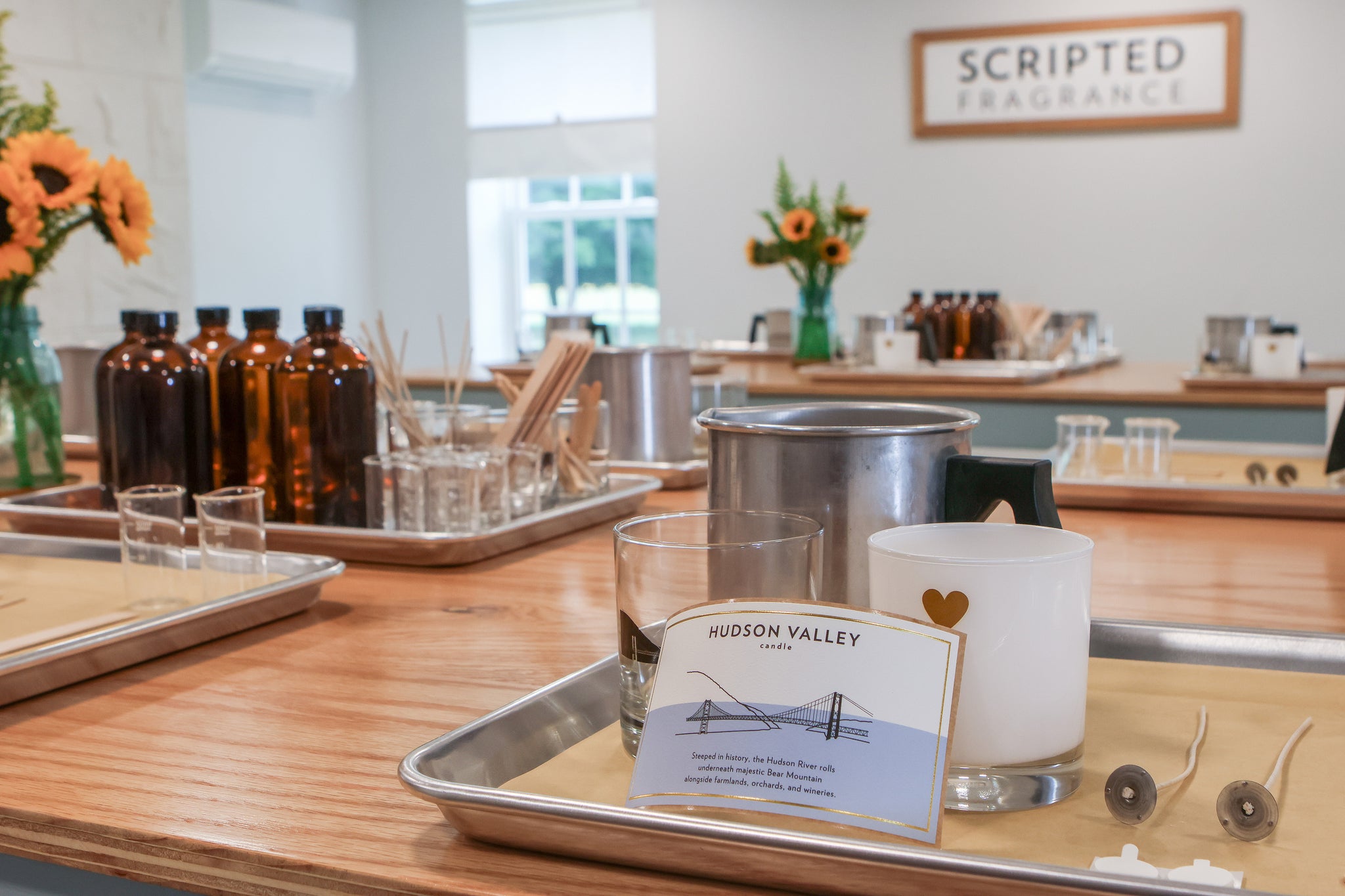 Fragrance oil bottles and supplies set up for a soy candle-making class