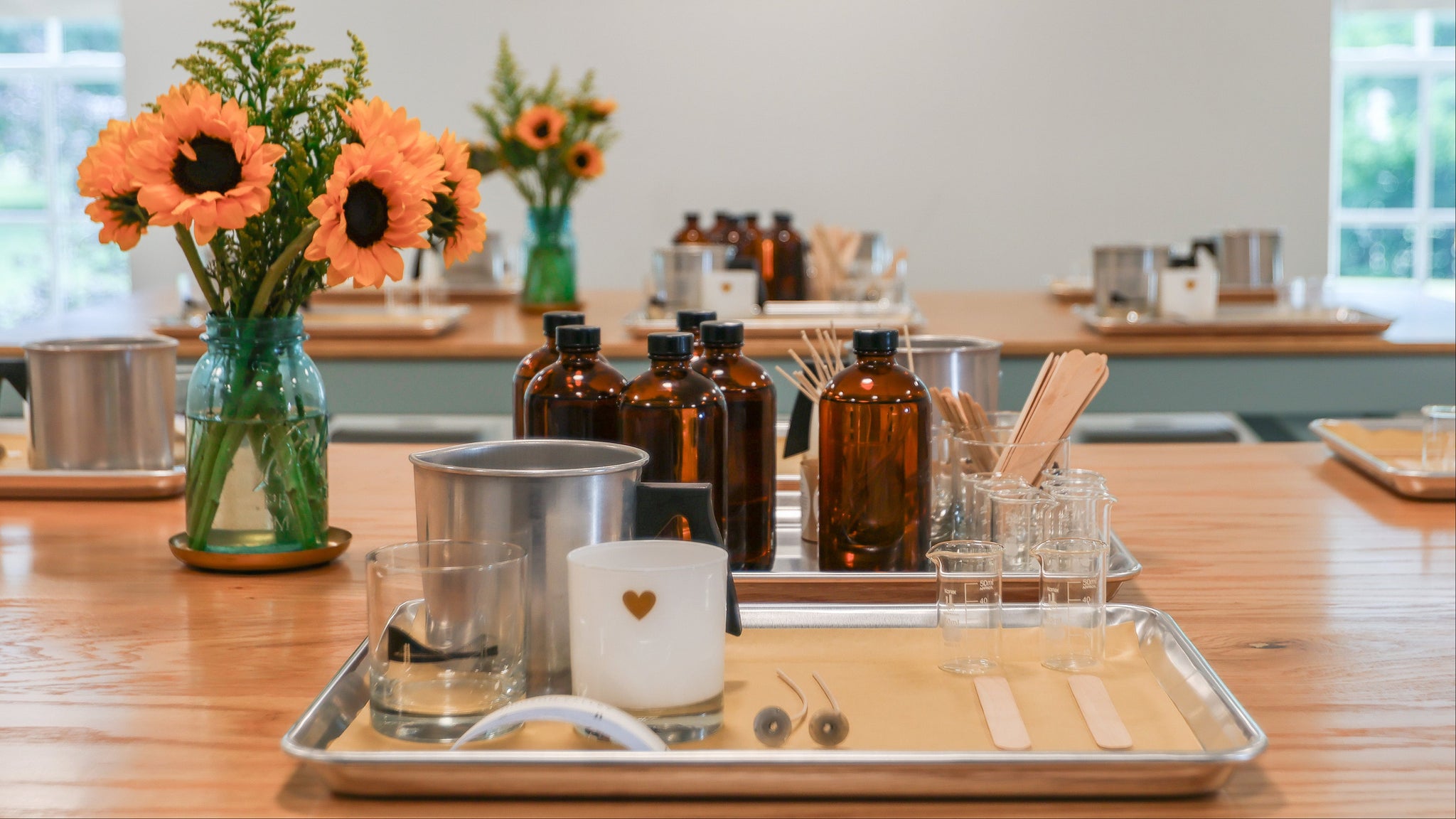 Workstation with flowers and glassware for a hands-on candle class