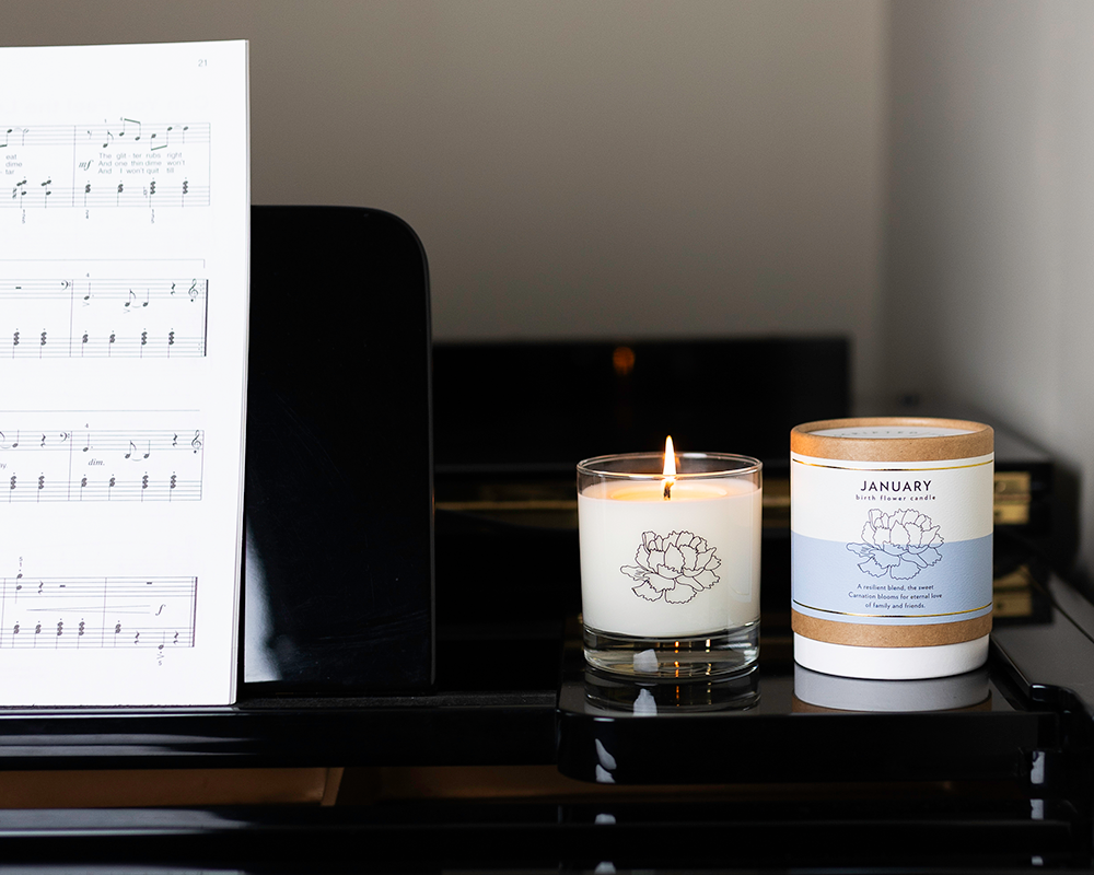 Birth month candle for January – floral notes of carnation with blue label on a piano