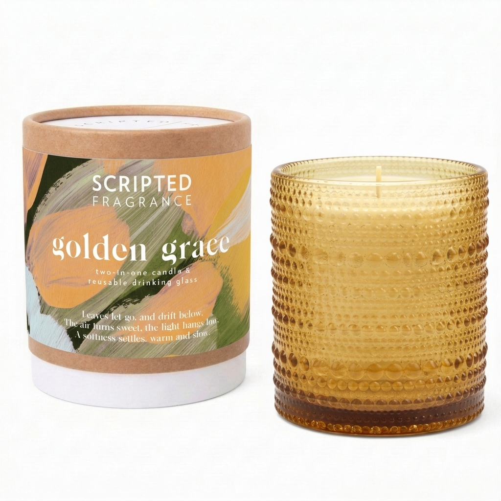 Golden Grace fall candle and reusable drinking glass by Scripted Fragrance, beside its kraft packaging with the Scripted Story poem label